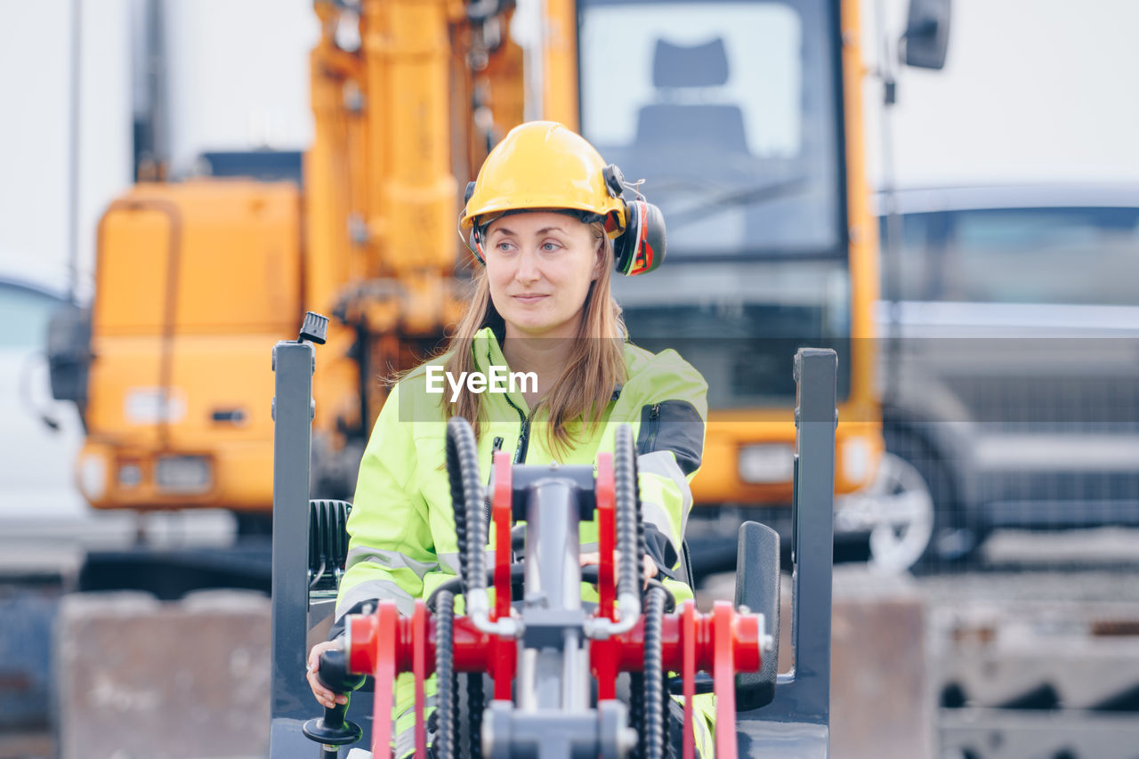 Woman with machinery at construction site