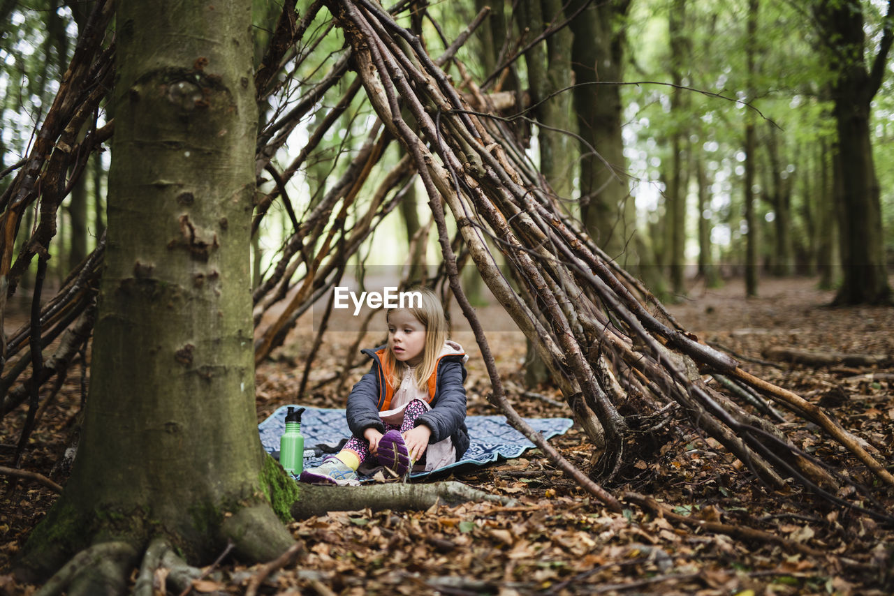 Girl in forest shelter