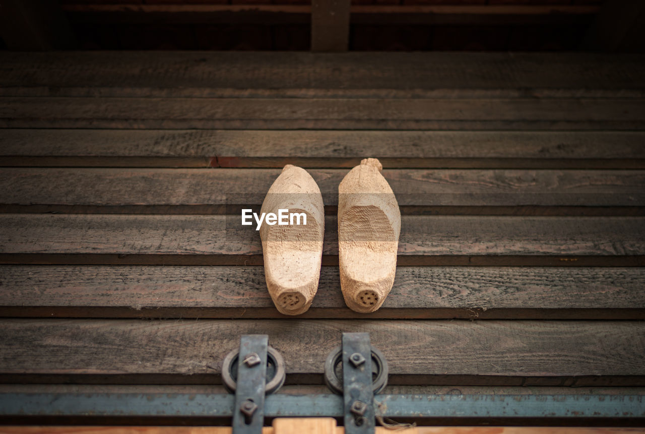 High angle view of wooden footwear on floorboard