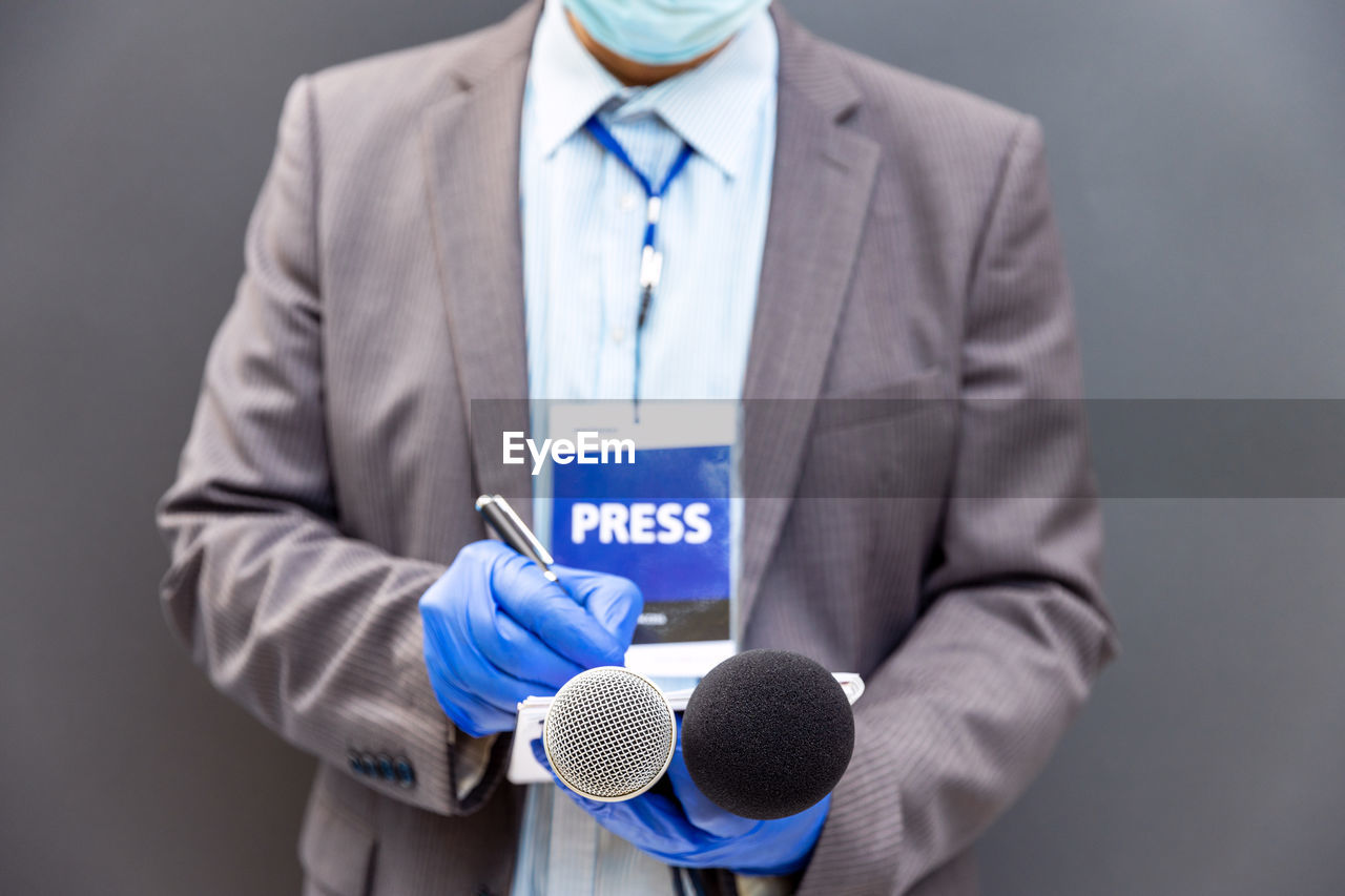 MIDSECTION OF MAN HOLDING DRESS