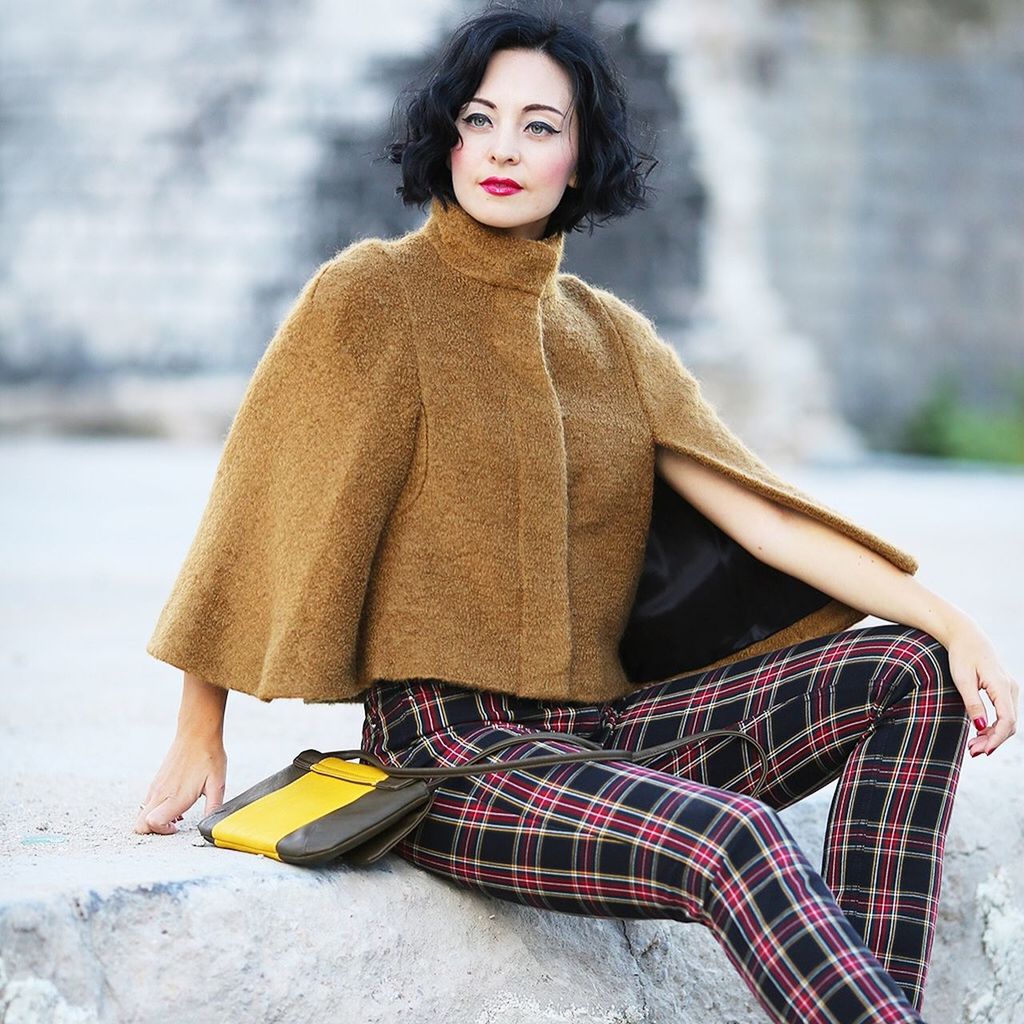 PORTRAIT OF A YOUNG WOMAN SITTING OUTDOORS