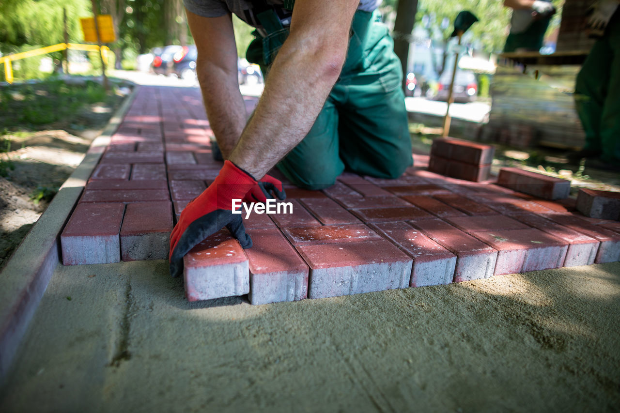 low section of woman walking on wooden bench