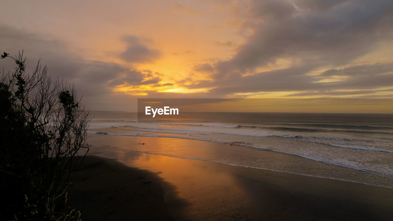 Scenic view of beach against sky during sunset