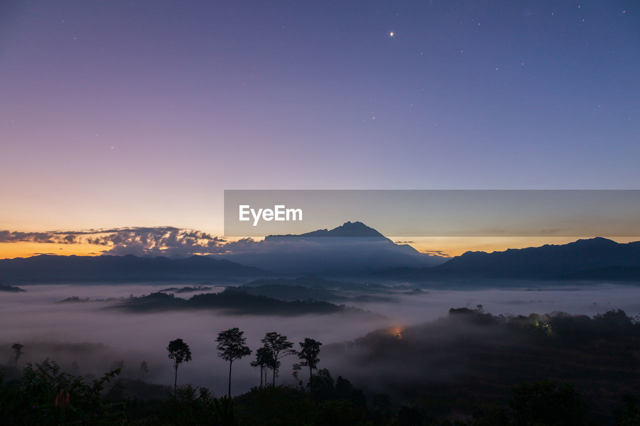 SCENIC VIEW OF SILHOUETTE MOUNTAINS AGAINST SKY AT NIGHT