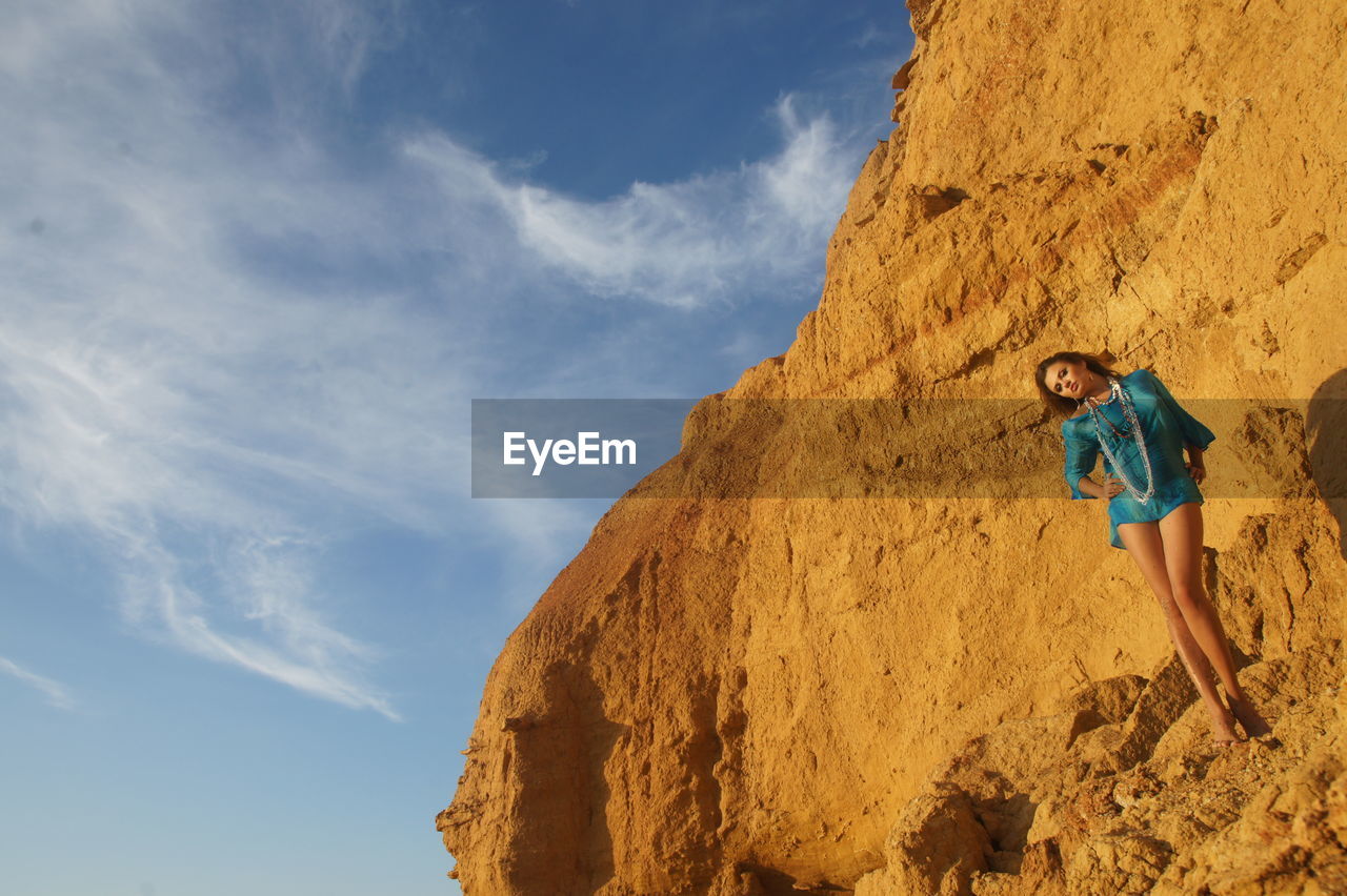 Full length of woman standing against rock face