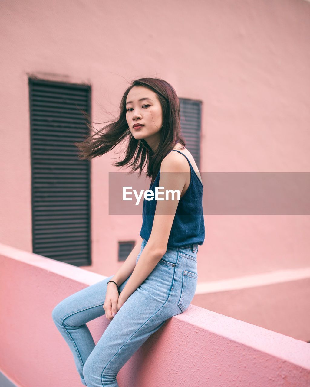 Beautiful young woman against wall