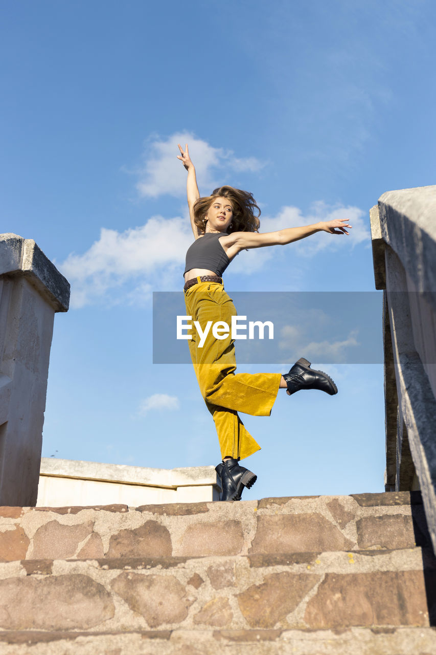 Young woman dancing on top of stone steps