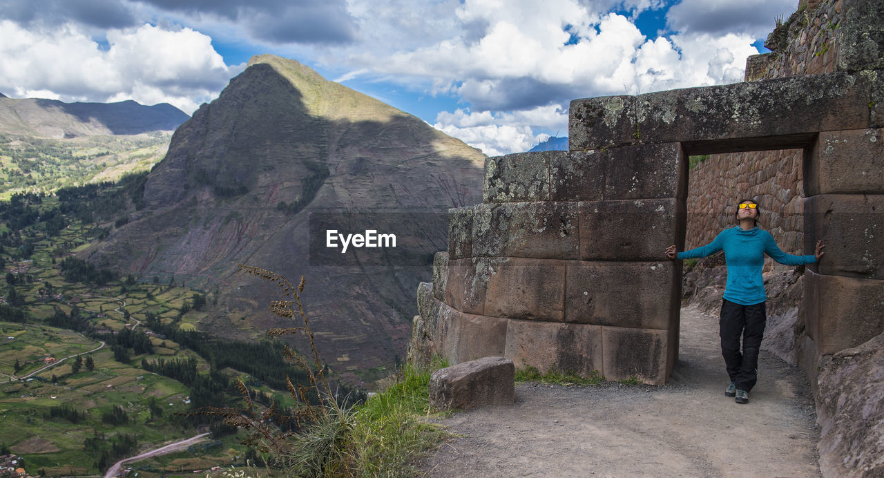 Woman exploring inca ruins above ollantaytambo, peru