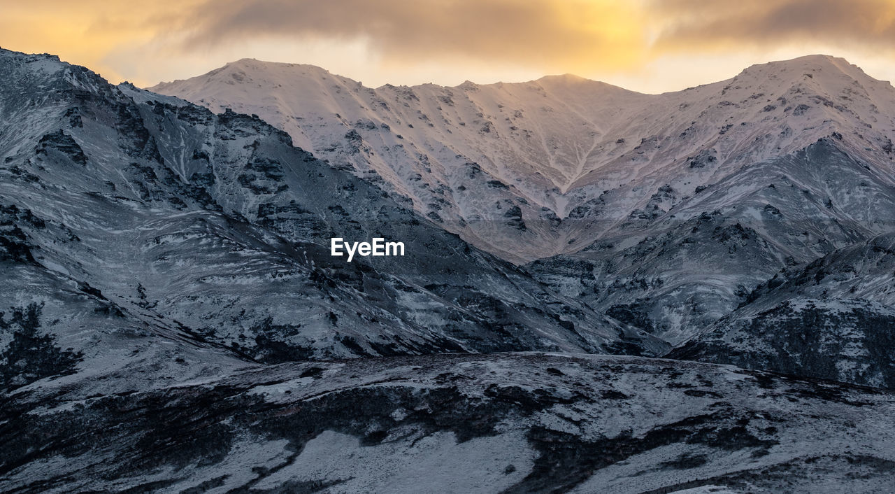 Scenic view of snowcapped mountains against sky during sunset