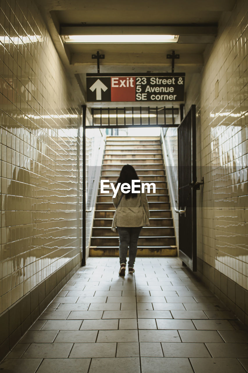 Rear view of woman walking up the stairs in subway in new york