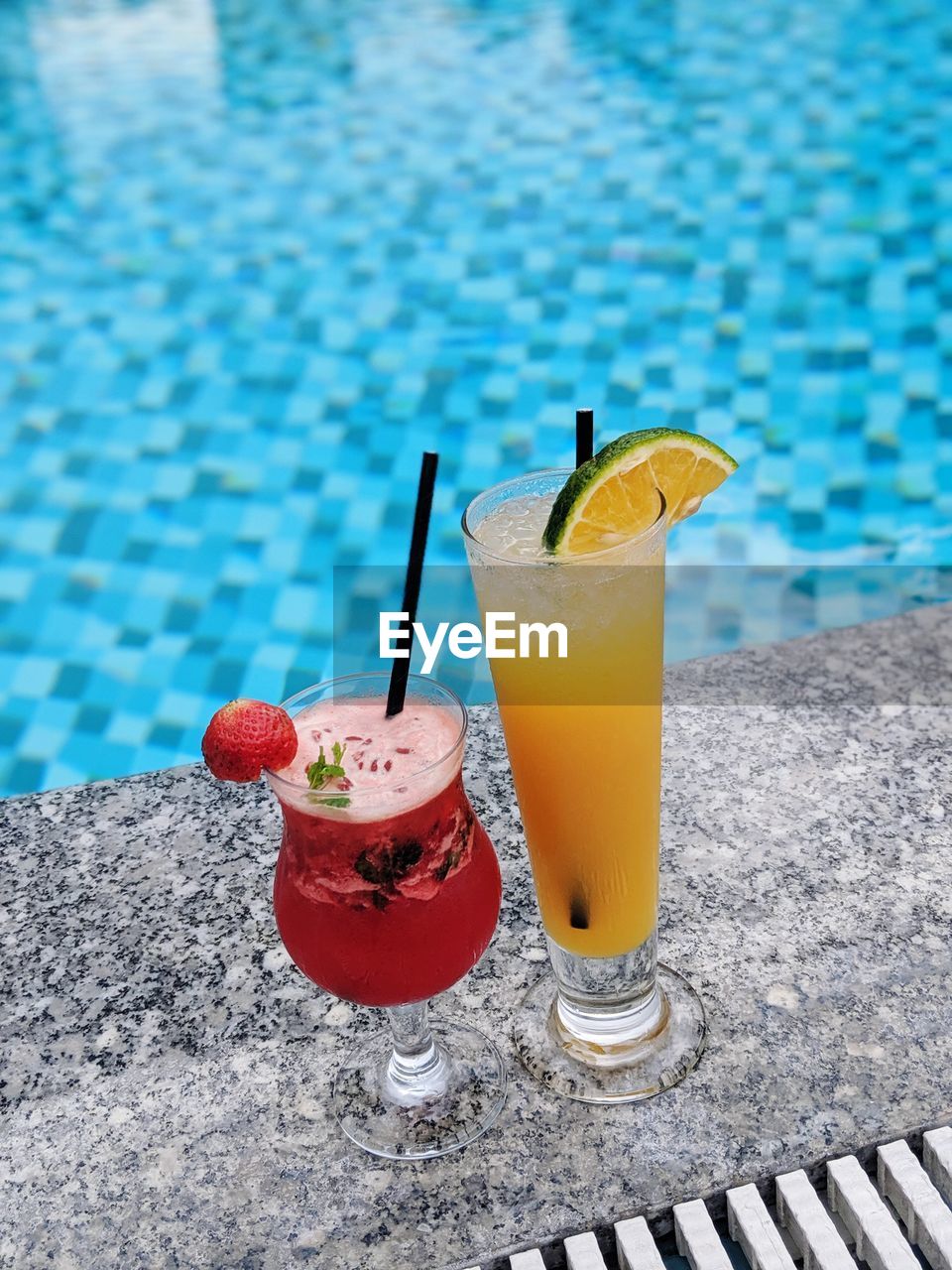 Close-up of drink on table against swimming pool