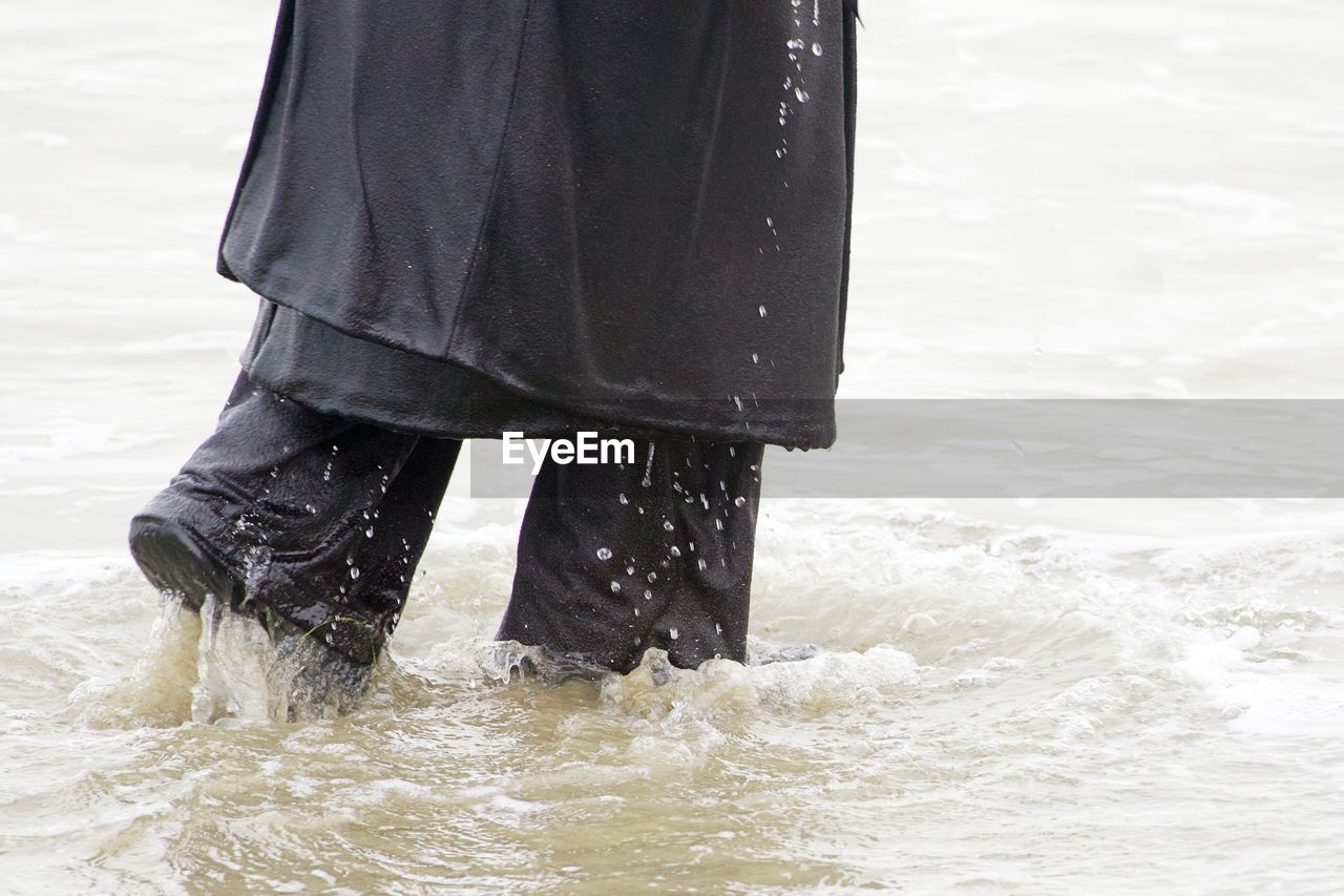 Low section of person walking at beach