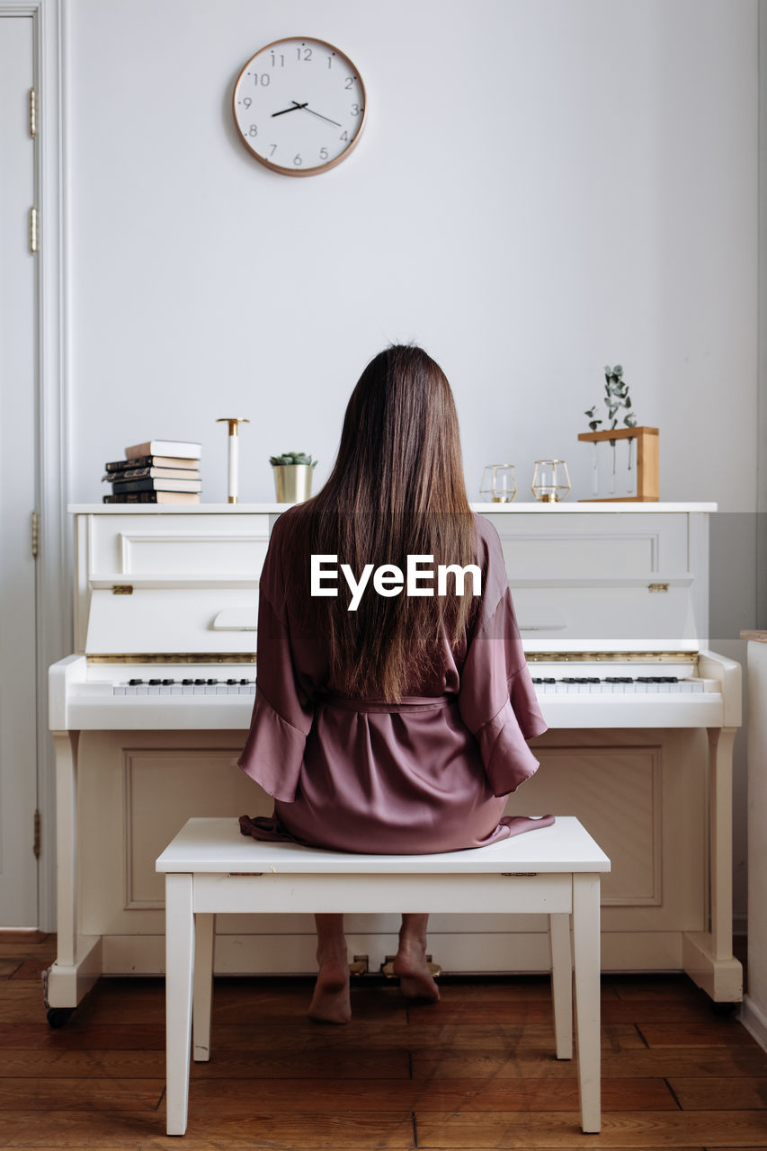 A beautiful woman playing the white piano