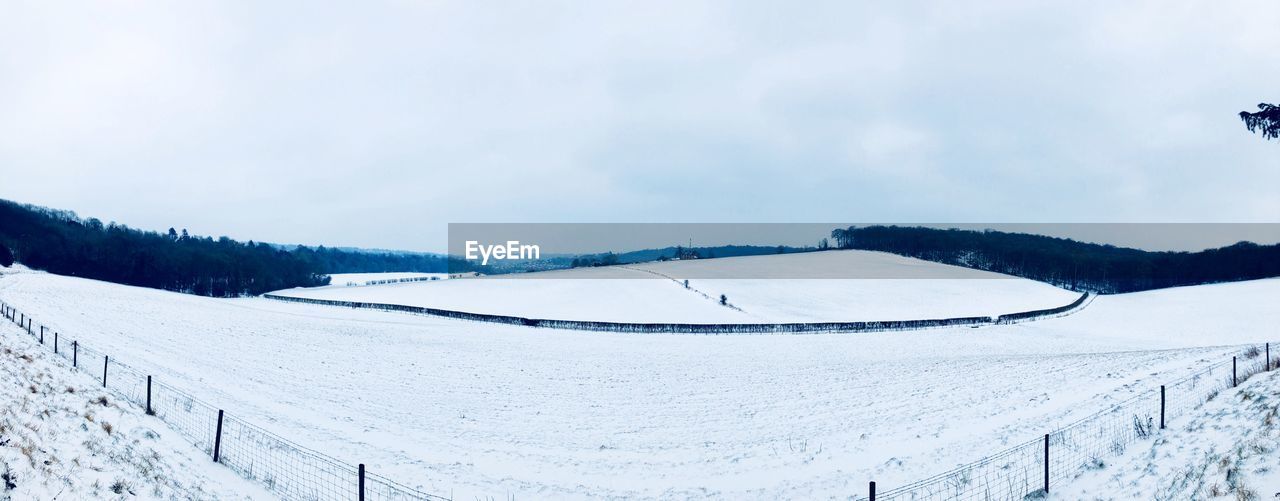 PANORAMIC VIEW OF SNOW COVERED LANDSCAPE AGAINST SKY