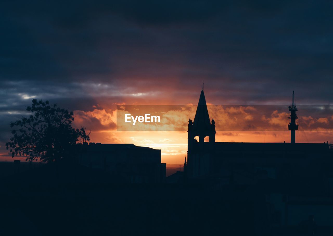 SILHOUETTE OF BUILDINGS AGAINST SKY DURING SUNSET