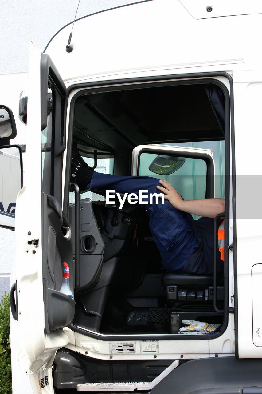 Low section of truck-driver relaxing in truck