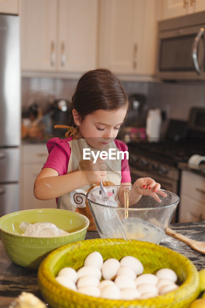 Cute girl preparing food in kitchen