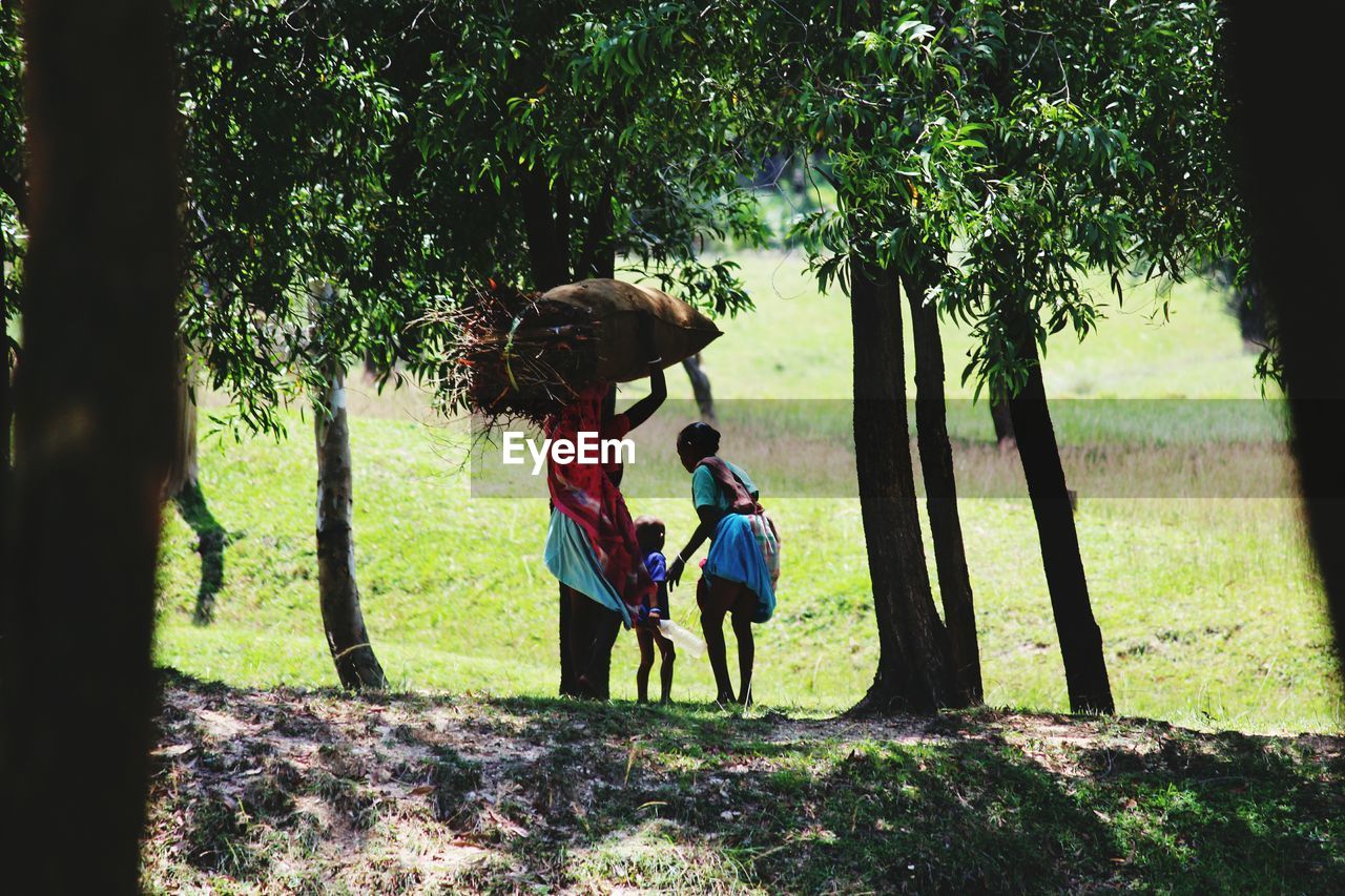 Women with boy standing on field