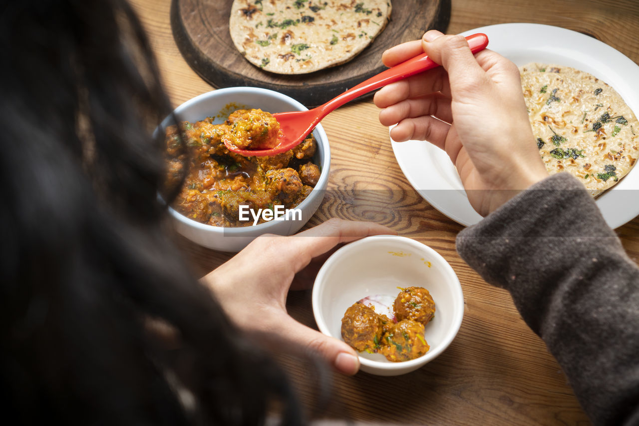 MIDSECTION OF WOMAN HOLDING FOOD