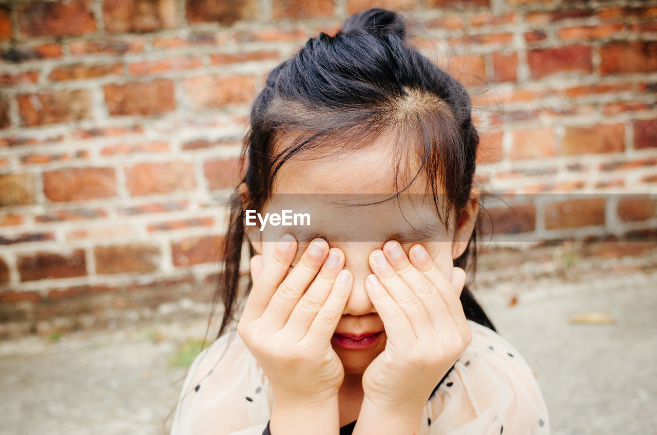 Close-up of girl covering eyes