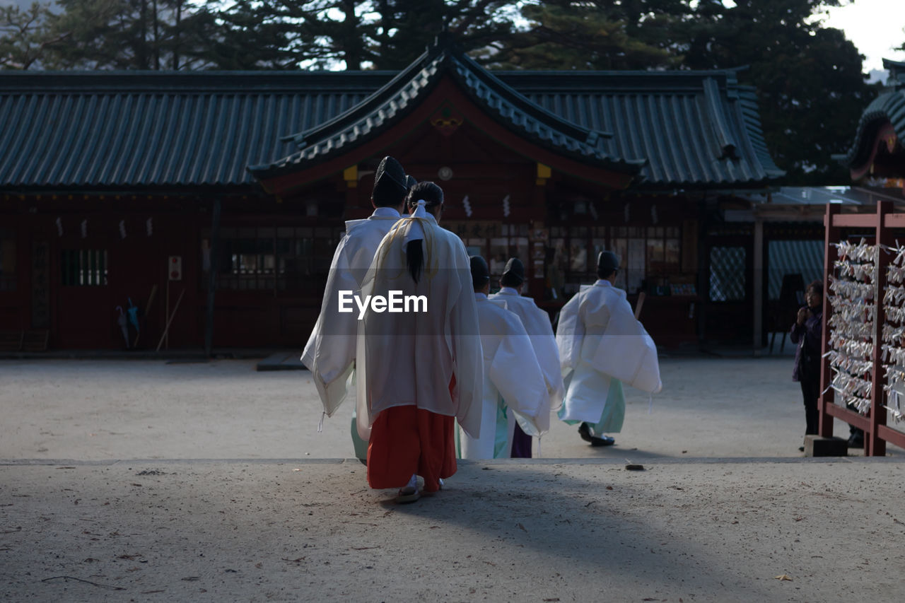 Rear view of people walking at temple