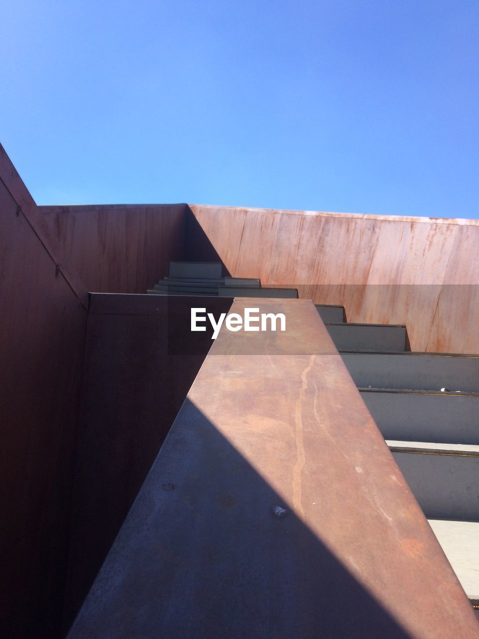 LOW ANGLE VIEW OF CONCRETE WALL AGAINST BLUE SKY