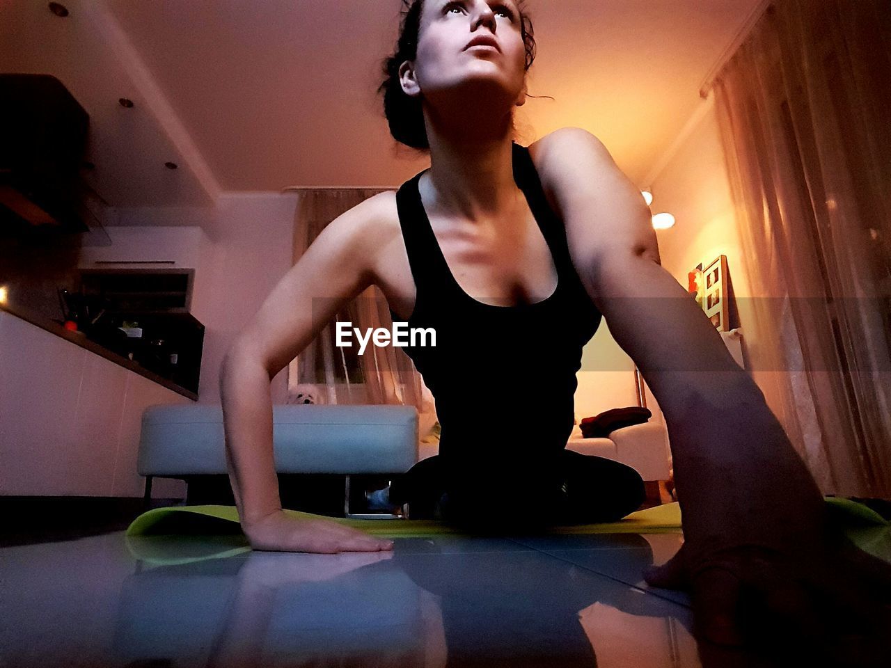 Low angle view of young woman doing yoga at home