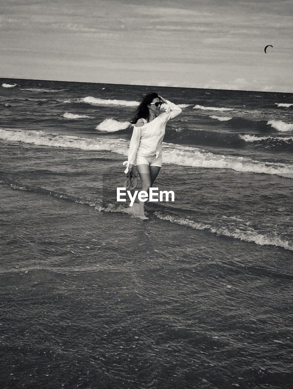 Woman standing on beach against sea