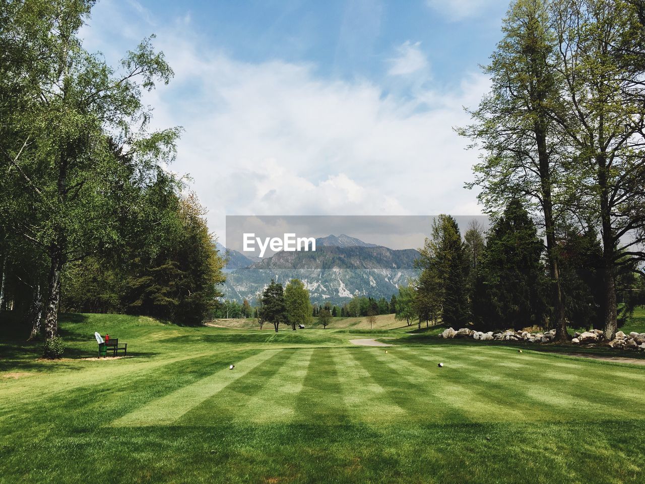 Scenic view of golf course against mountain peak