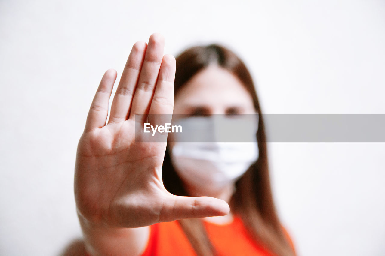 Portrait of woman holding hands over white background