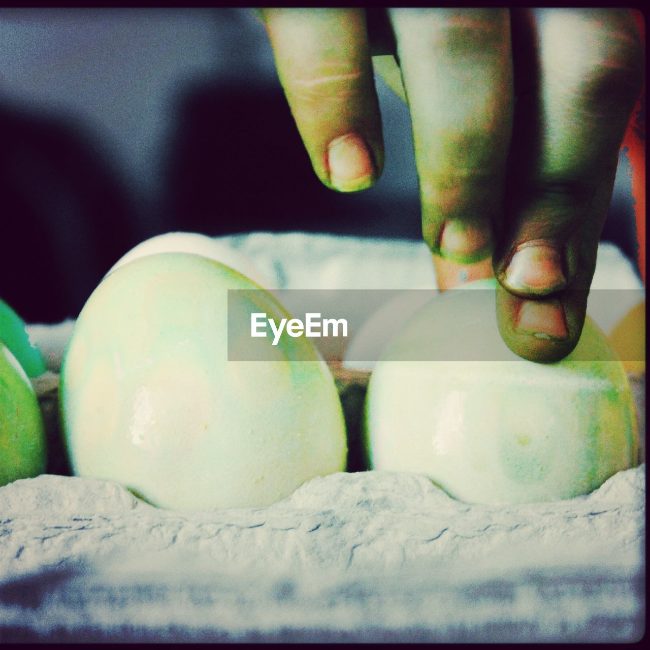 Close-up of hand holding white eggs