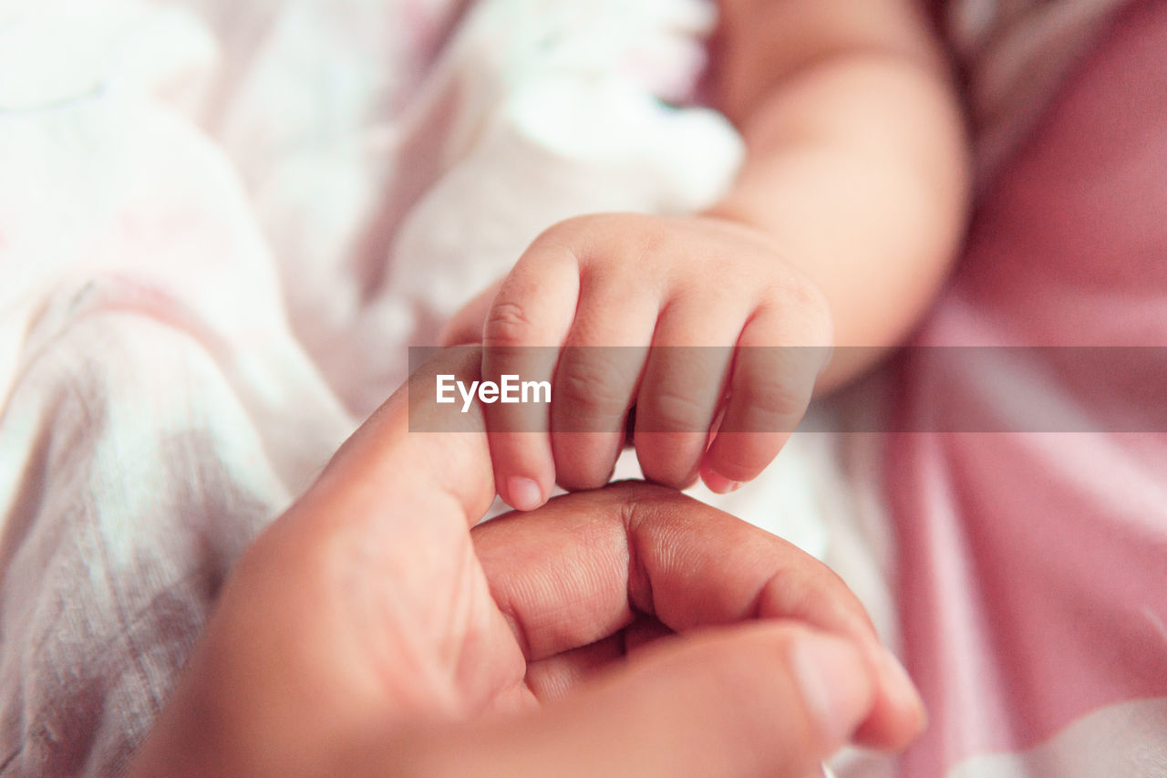 CLOSE-UP OF BABY HAND WITH TATTOO