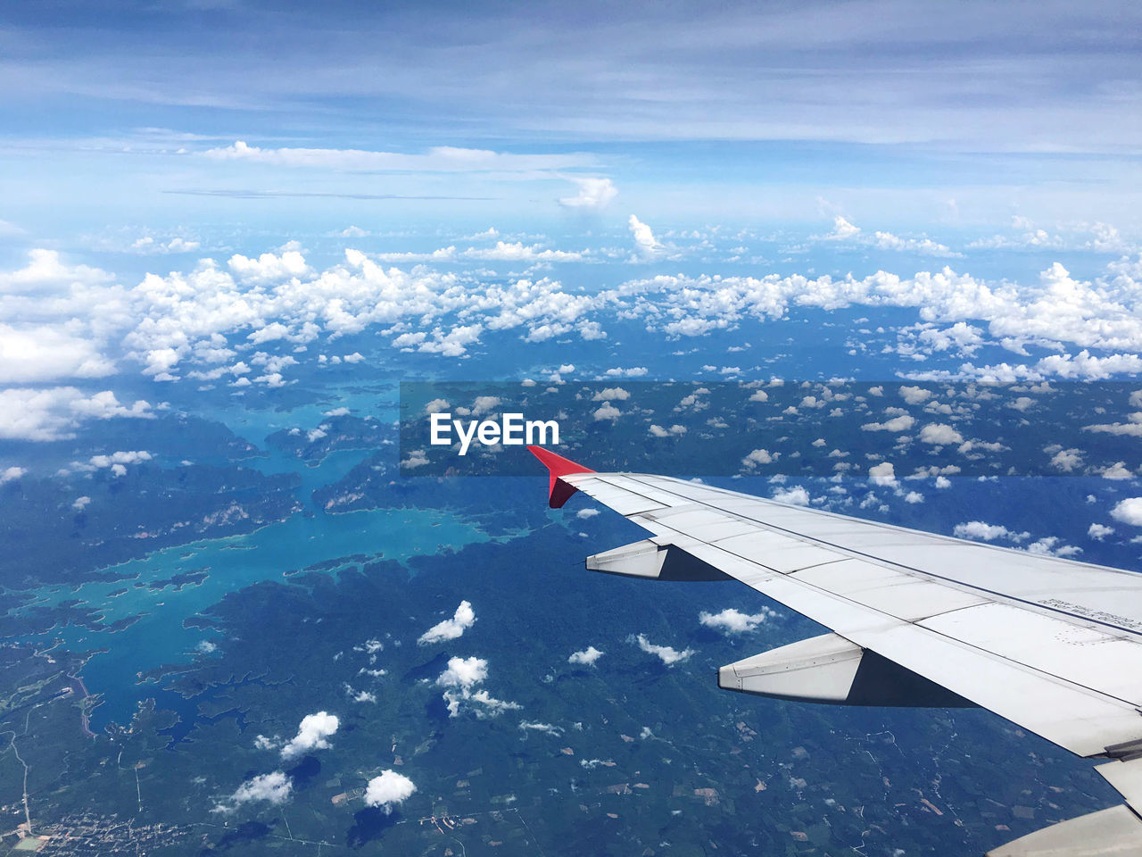 AERIAL VIEW OF AIRPLANE FLYING OVER CLOUDS