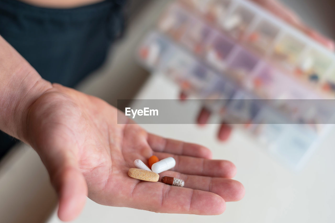 cropped hand of person holding pills