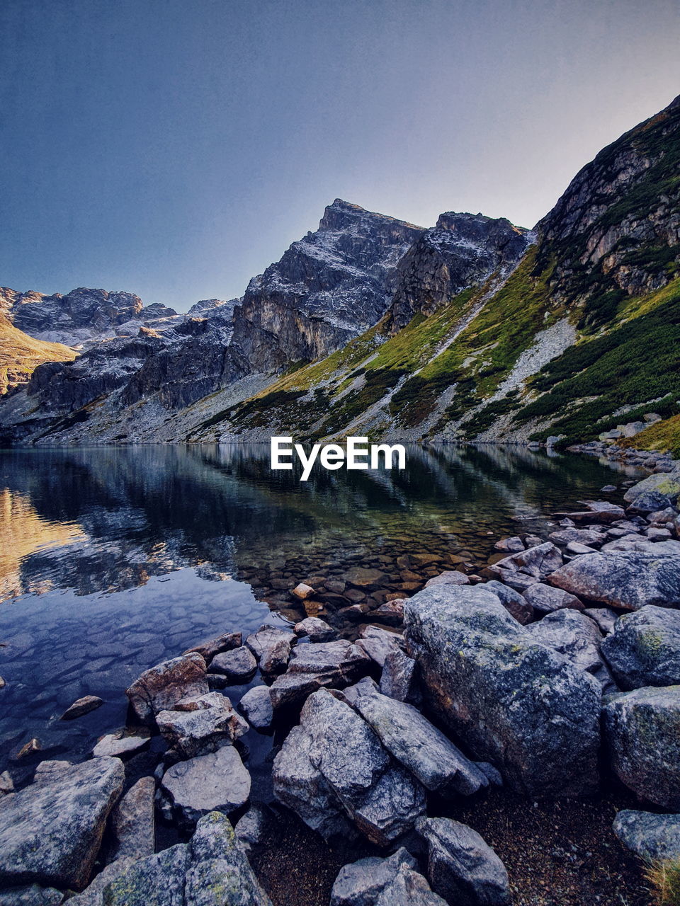 Scenic view of lake and mountains against clear sky