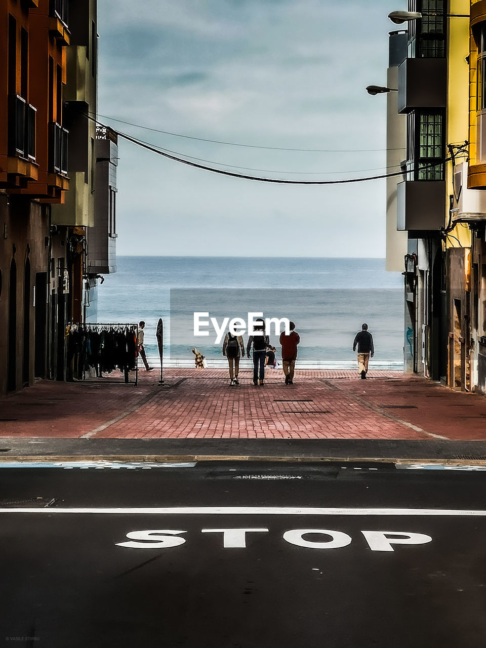 People by sea against sky in city