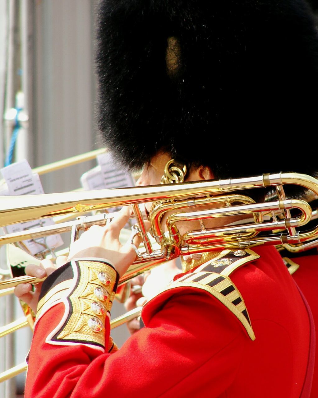 Side view of british royal guard with brass instrument on shoulder
