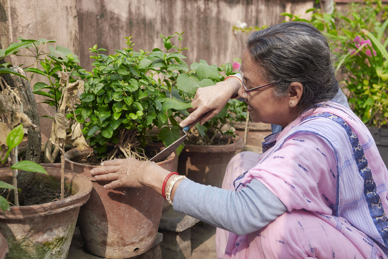 Portrait of a simple looking mature indian woman working in rooftop garden
