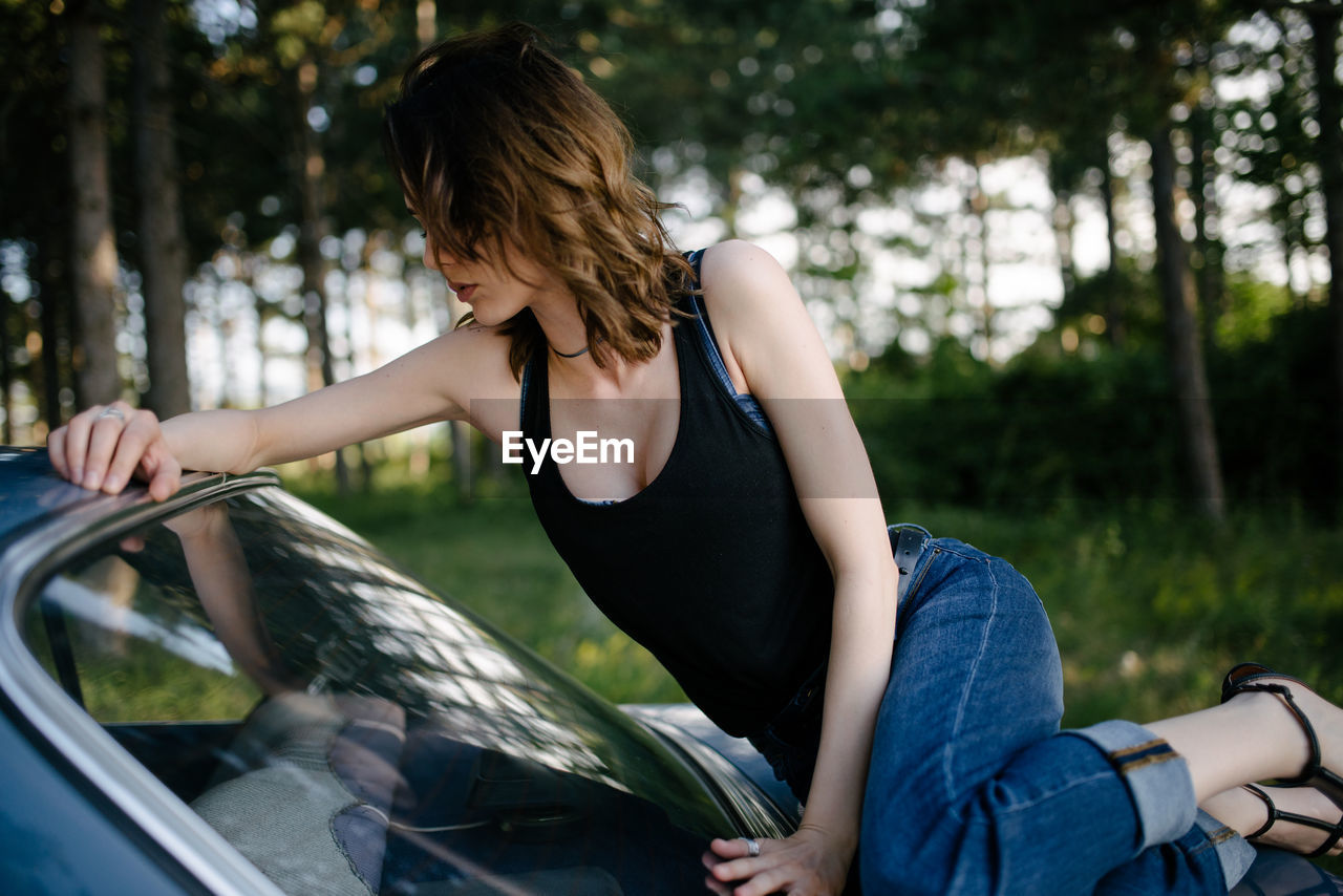 Young woman is resting on vintage car