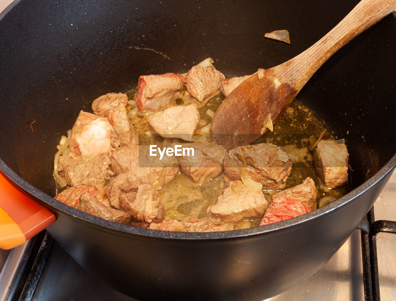 HIGH ANGLE VIEW OF MEAT COOKING IN PAN