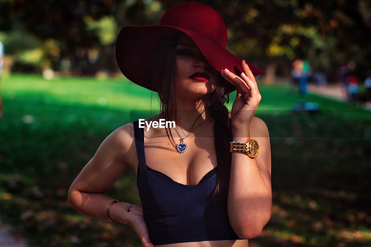 Portrait of sensuous woman wearing red hat in park
