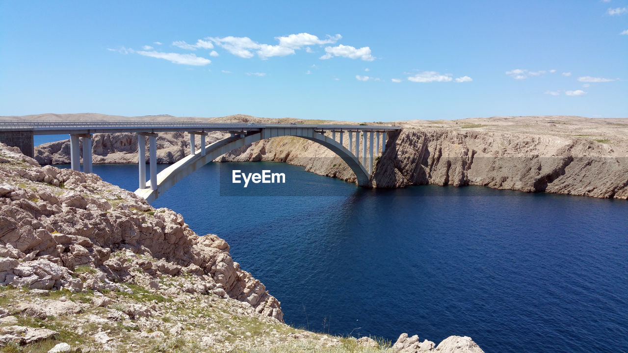 Pag bridge over bay of water against sky