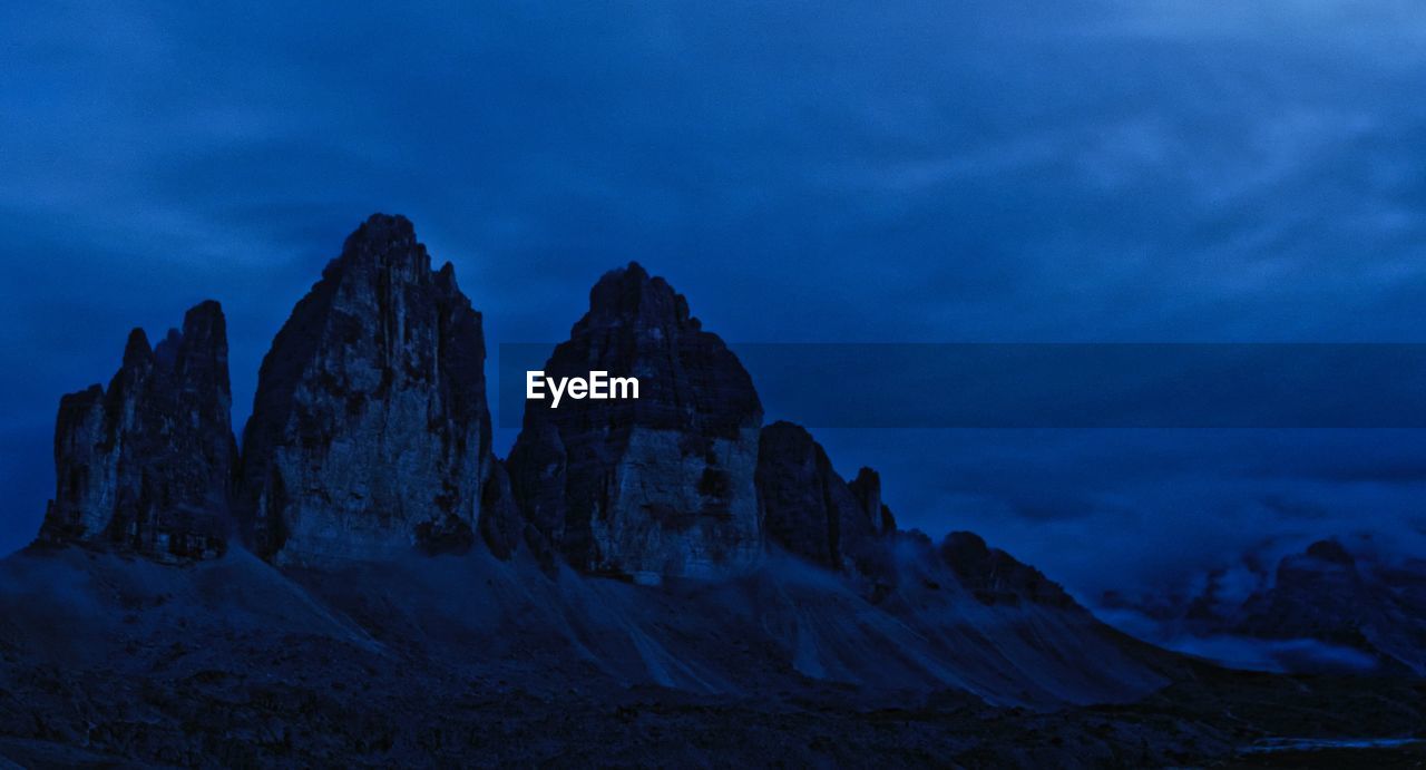 Rock formations against sky at dusk