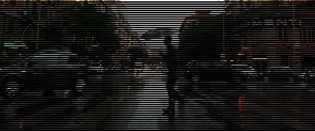 Digital composite image of man walking on street by cars amidst buildings