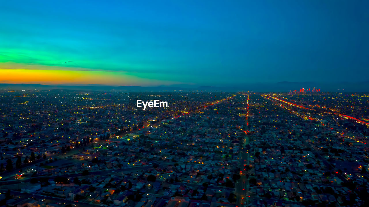 Aerial view of illuminated cityscape against sky at night