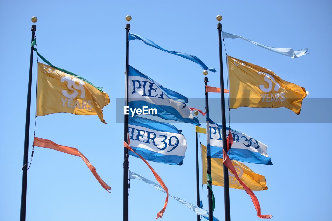 LOW ANGLE VIEW OF FLAG FLAGS AGAINST CLEAR BLUE SKY