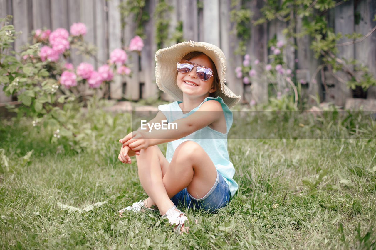 Smiling girl sitting in grass at yard