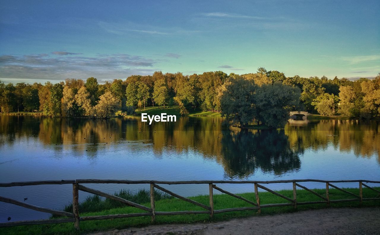 Scenic view of lake by trees against sky