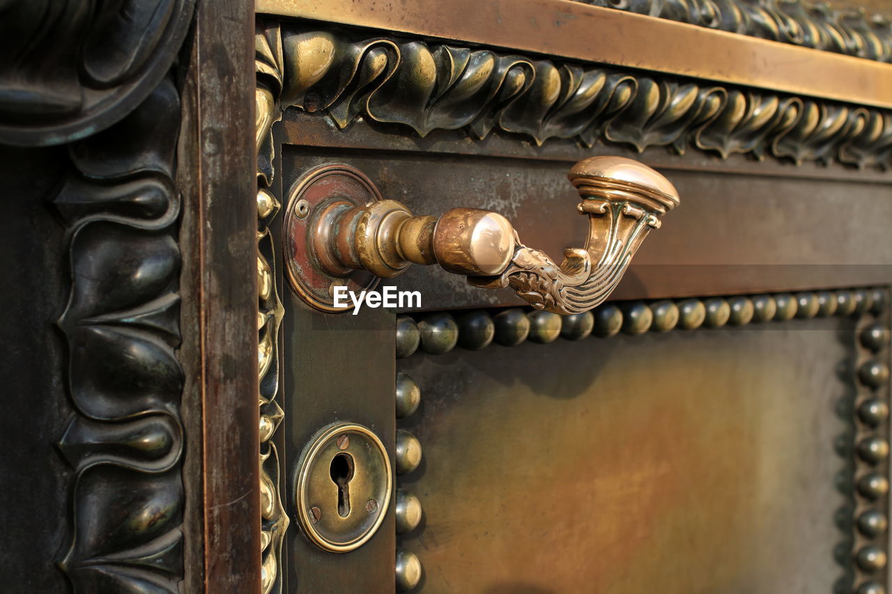 CLOSE-UP OF ORNATE DOOR KNOCKER ON WOODEN BUILDING