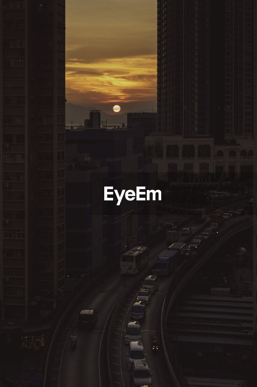 High angle view of street amidst buildings in city during sunset